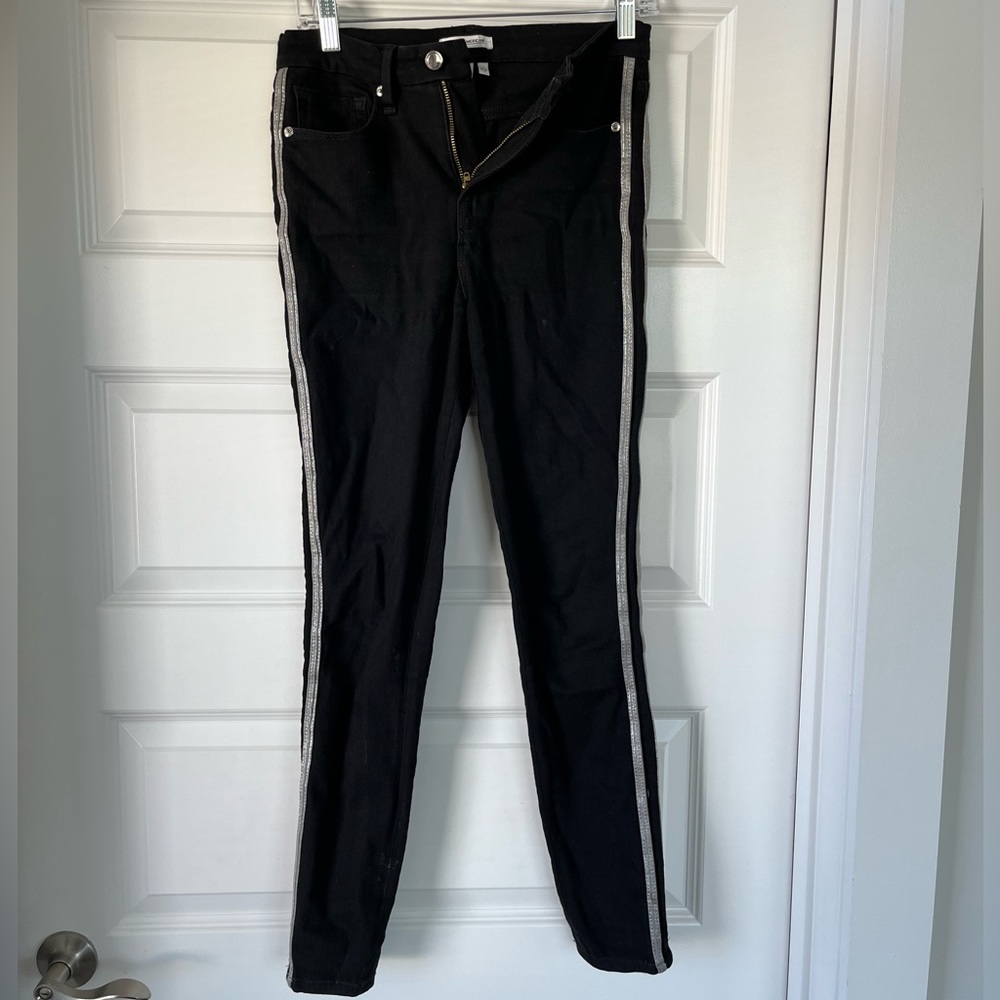 Good American black jeans with silver stripes down the side.